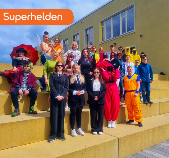 Gruppe von Menschen in Kostümen vor einem Gebäude.
