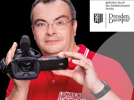 Ein Mann hält eine HD-Kamera und trägt ein rotes Hemd.