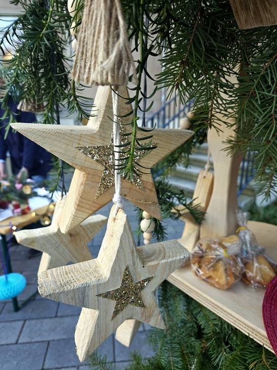 Holzsterne hängen an einem Weihnachtsbaum.
